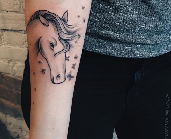 Cabeça de cavalo com desenho de tatuagem de borboleta no antebraço 