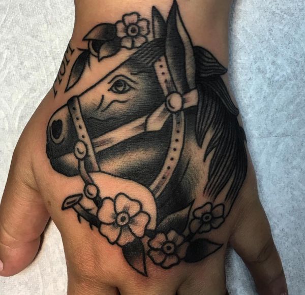 Tatuagem de cabeça de cavalo com flores na mão 