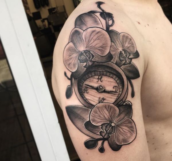 Tatuagem de orquídea com bússola no braço dos homens 