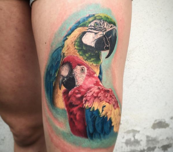 Tatuagem de dois papagaio na coxa 