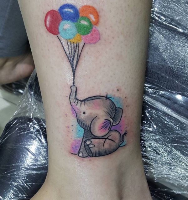 Tatuagem de elefante colorido com balão na perna 