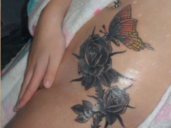 Tatuagem de rosa escuro com uma borboleta 