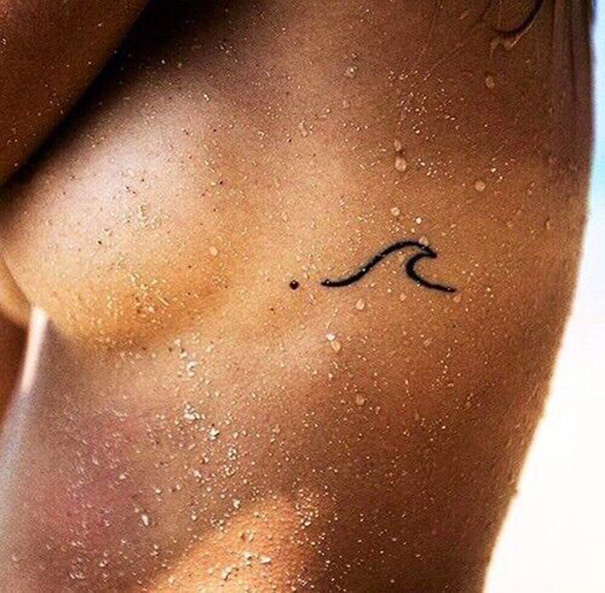 tatuagem de onda na costela 