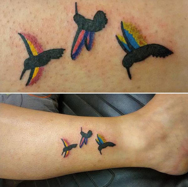 Pequena tatuagem colorida de beija-flor na parte inferior da perna 
