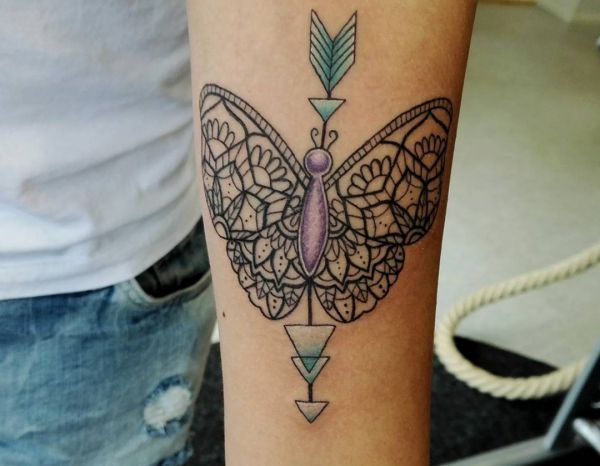 Desenho de tatuagem de borboleta de mandala e seta no antebraço 