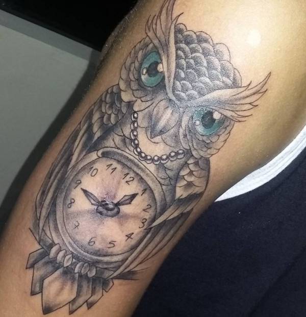 Tatuagem de coruja com relógio no braço 