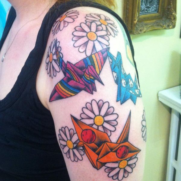 Margaridas e tatuagem de guindaste de origami no braço 