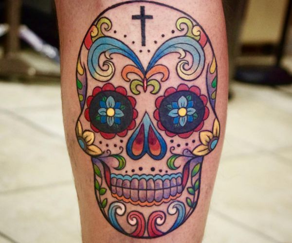 Desenho de tatuagem de caveira de açúcar colorido na perna 