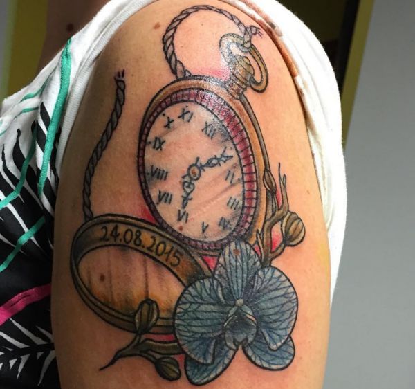 Relógio antigo com desenho de flores e datas no braço 