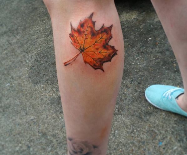 Tatuagem de folhas amarelas na parte inferior da perna 