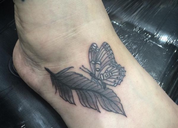 Pena com tatuagem de borboleta a pé para mulher 