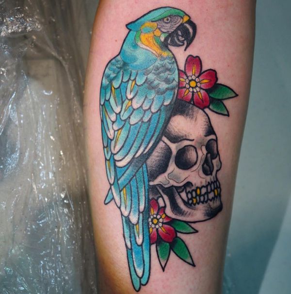 Tatuagem de papagaio com caveira na perna 
