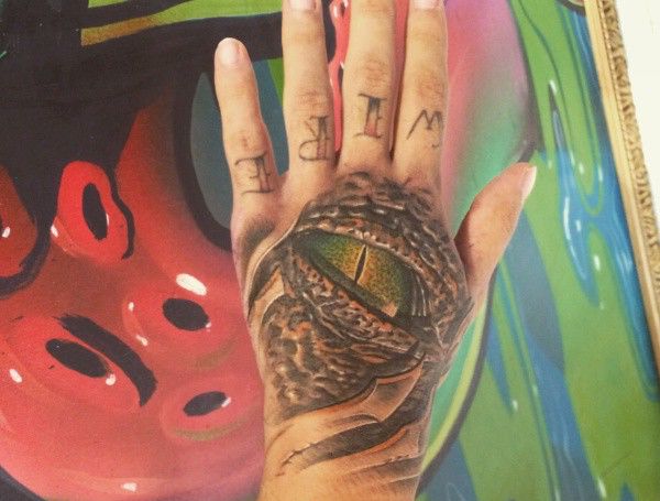 Motivos de tatuagem de olho de crocodilo na mão 