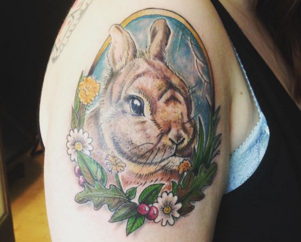 Coelho com desenho de tatuagem de retrato de flores no braço 