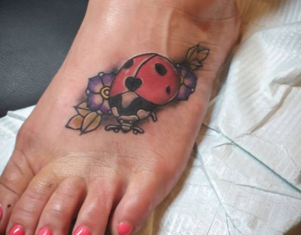Joaninha com tatuagem de flores no pé 