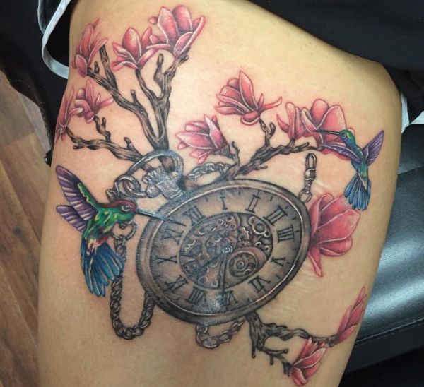 Tatuagem de relógio antigo com beija-flor e flores na coxa 
