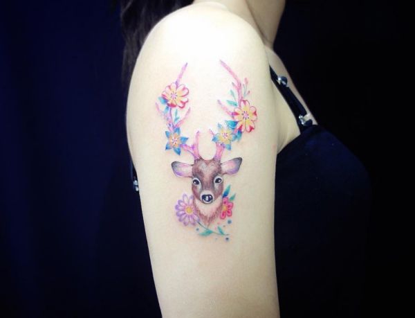 Cabeça de veado com desenho de tatuagem de flor na mulher de braço 
