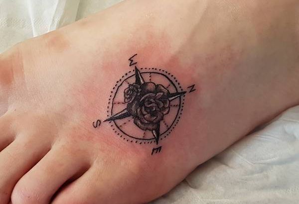 Tatuagem de bússola pequena com flor no pé 