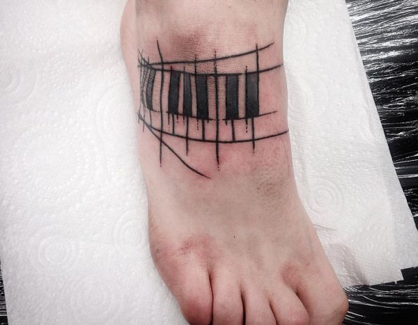 Piano com a tatuagem do pé de botões 