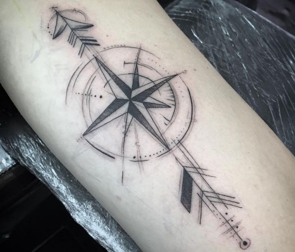 Tatuagem estrela bússola abstrata no braço 