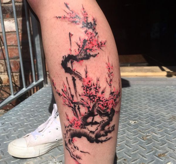 Design de flor de cerejeira em aquarela na perna 