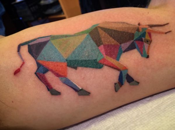 Tatuagem de touro colorido geométrico no braço 