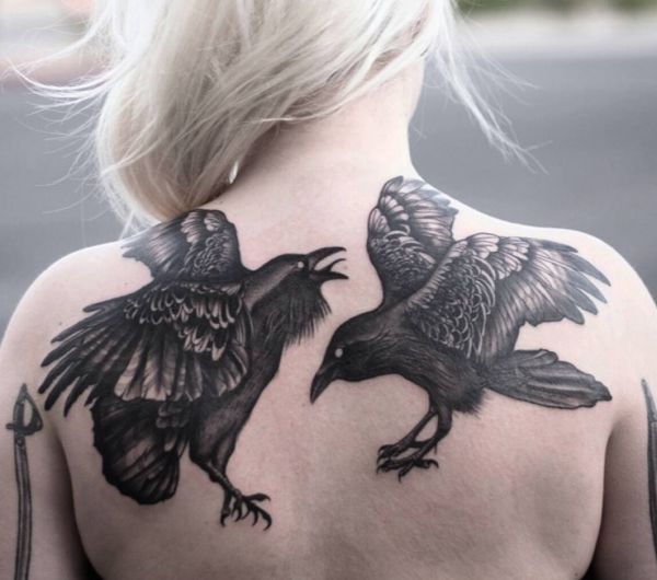A tatuagem de dois corvos na parte de trás para mulher 