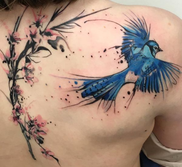 Flores de cerejeira em aquarela e tatuagem de pássaro nas costas 