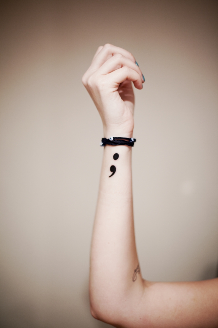 pequenos símbolos braços tatuados 