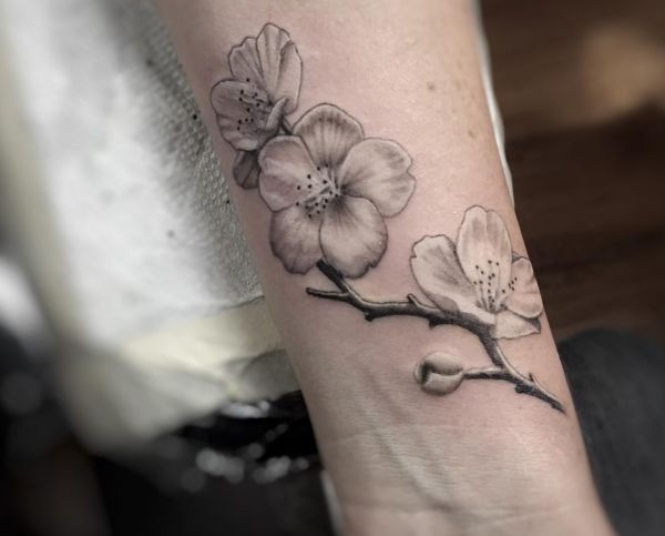 Design de tatuagem de flor de cerejeira no pulso preto e branco 