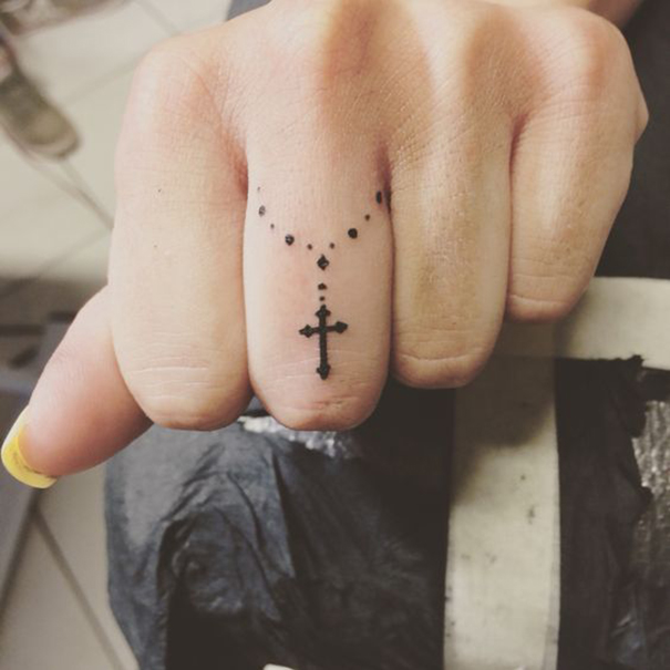 Cruz tatuagem no dedo 