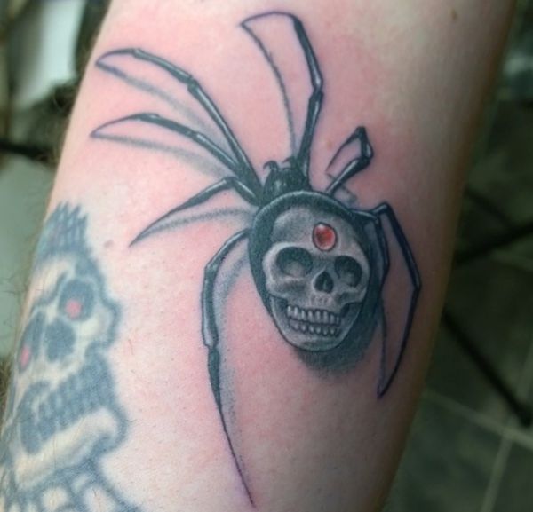 Tatuagem de aranha com caveira no braço