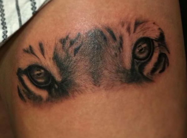 Tatuagem de olho de tigre na coxa 