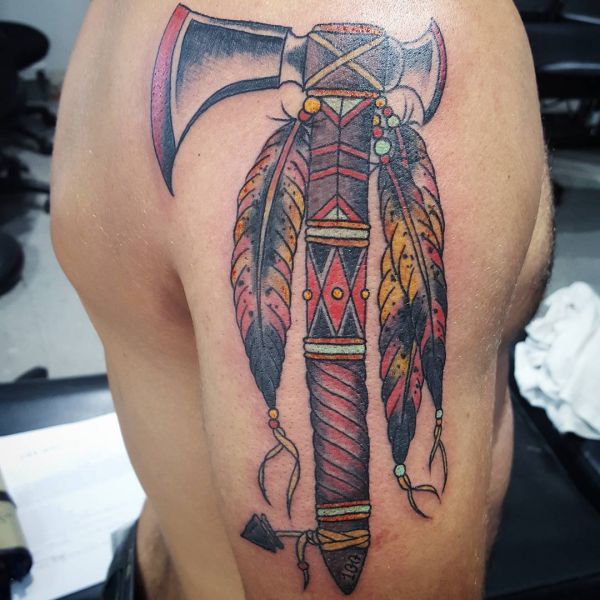 Machado com penas indígenas Tatuagem no braço 