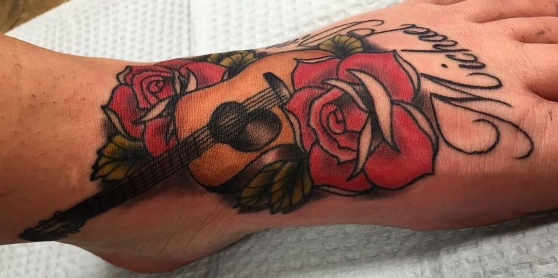 Tatuagem de pé de guitarra e rosa 