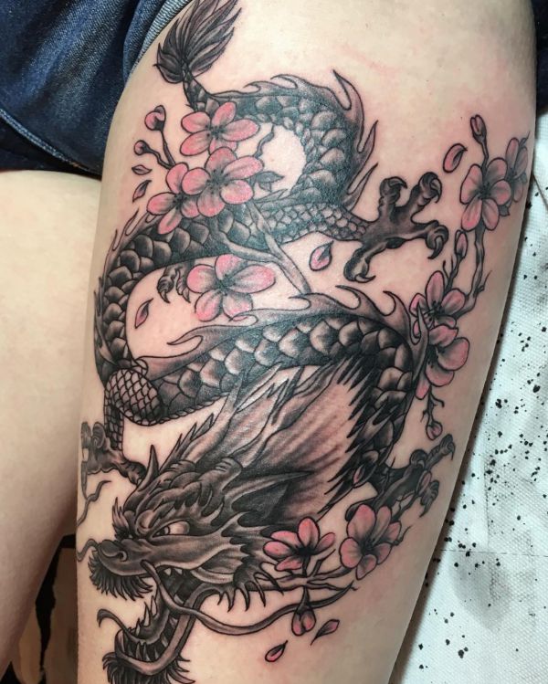 Tatuagem de dragão japonês com flores na coxa para mulheres 