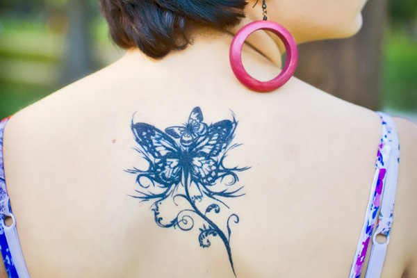 Tatuagem de borboleta de estilo tribal nas costas 