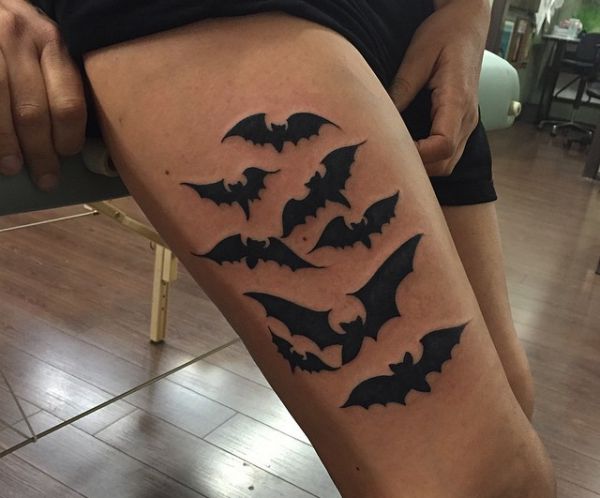 Tatuagem de enxame de morcego na perna para mulher 