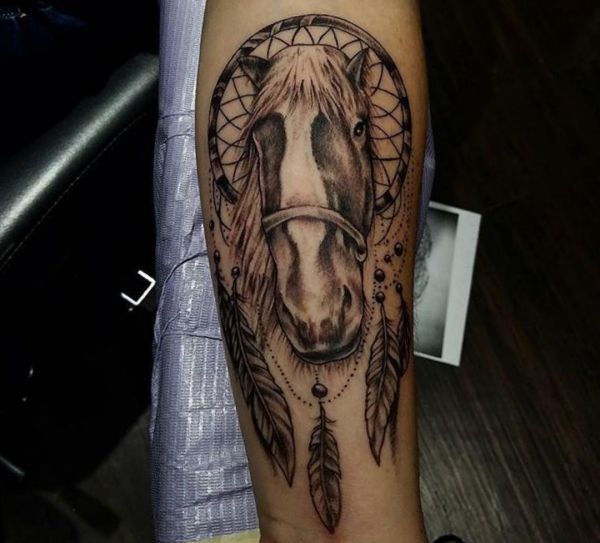 Apanhador de sonhos com desenho de cavalo no braço 