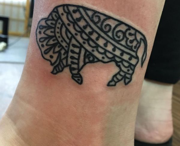 Tatuagem de búfalo tribal na perna 