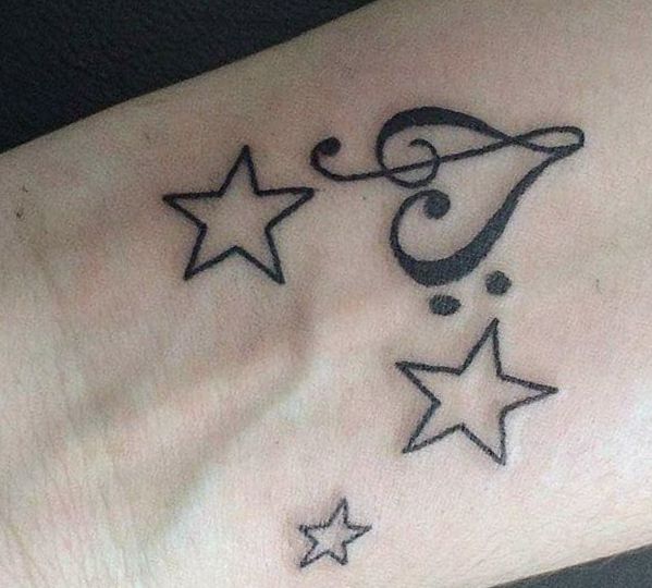 Estrelas tatuagem com símbolos musicais no pulso 