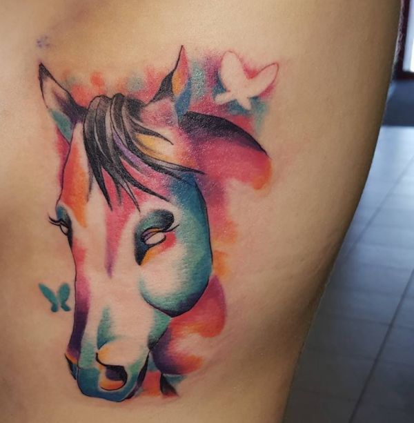 Tatuagem de cabeça de cavalo aquarela com borboleta na coxa 