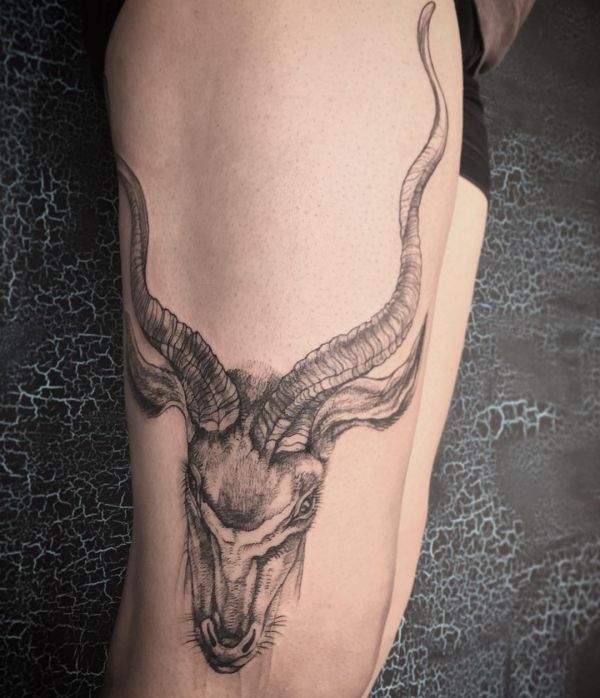 Tatuagem gazela com longos chifres na coxa 