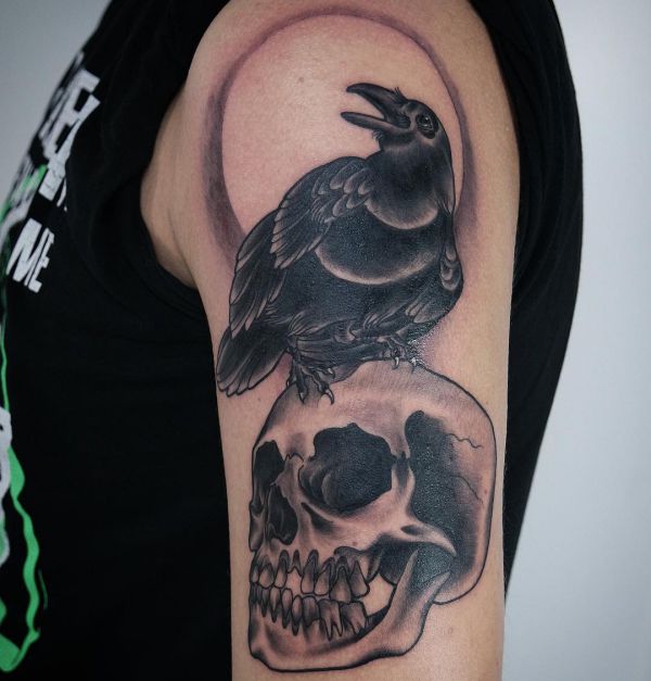 Tatuagem de caveira e corvo no braço 