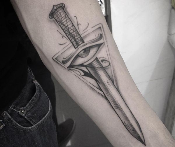 Espada com desenho de olho de Horus no antebraço 