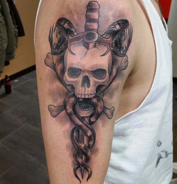 Tatuagem de duas cobras com espada e crânio 