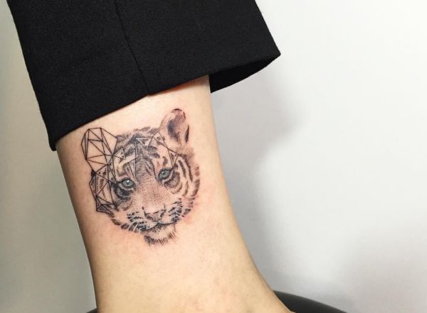 Tatuagem de cabeça de tigre pouco abstrata na parte inferior da perna 