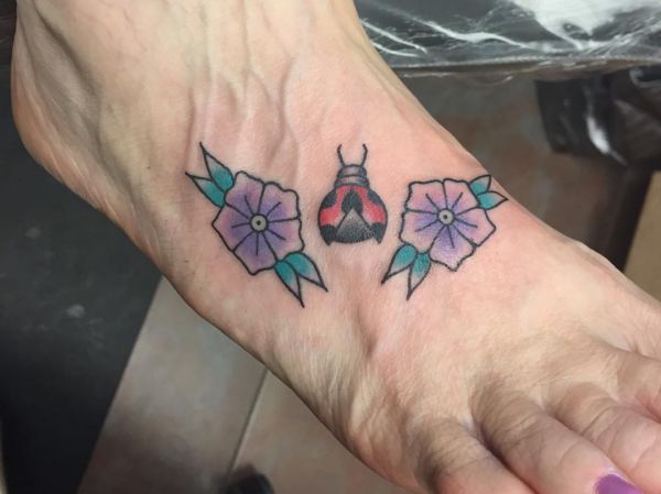 Joaninha com design de tatuagem de flor no pé 