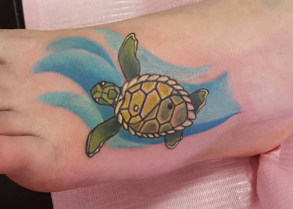 Tatuagem de água e tartaruga no pé 