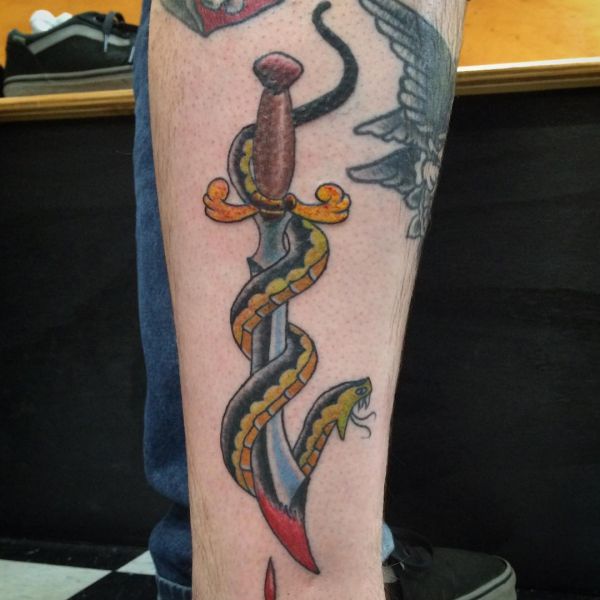 Tatuagem de espada com cobra na perna 